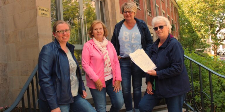 Vier Frauen stehen mit einer Unterschriftenliste vor dem Waltroper Rathaus.