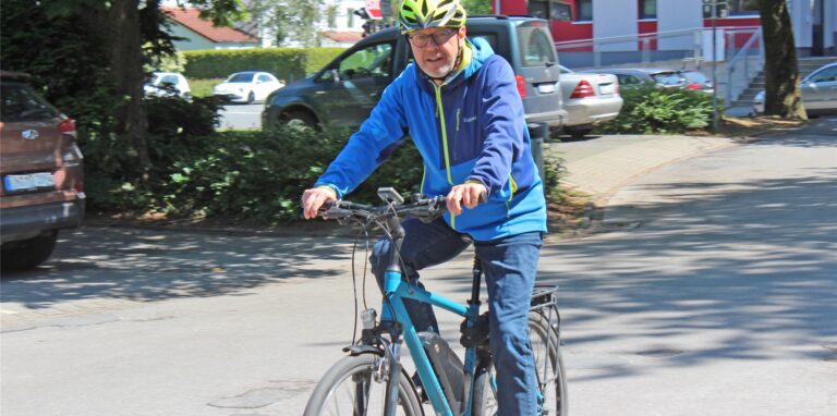 Burkhard Tiessen radelt auf den Parkplatz vor dem Waltroper Rathaus.