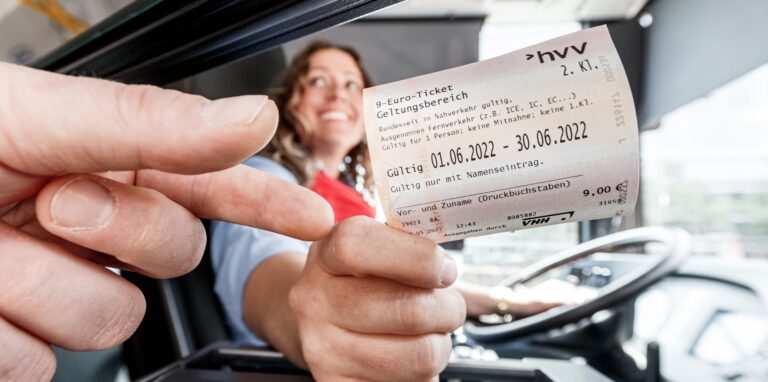 Busfahrerin Miriam Kara gibt einem Kunden sein 9-Euro-Ticket.