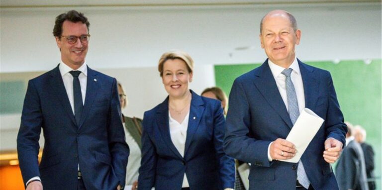 Bundeskanzler Olaf Scholz (SPD) kommt neben Hendrik Wüst (CDU), Ministerpräsident von Nordrhein-Westfalen, sowie Franziska Giffey (SPD), Regierende Bürgermeisterin von Berlin, zur Pressekonferenz nach der Ministerpräsidentenkonferenz.