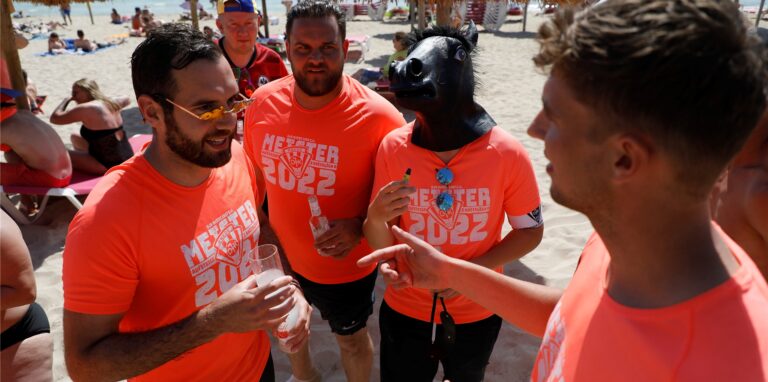 Yannick (l) und Freunde nehmen einen Drink im Sand am Strand von Arenal. Der Ballermann auf Mallorca feiert sein 50-jähriges Jubiläum.