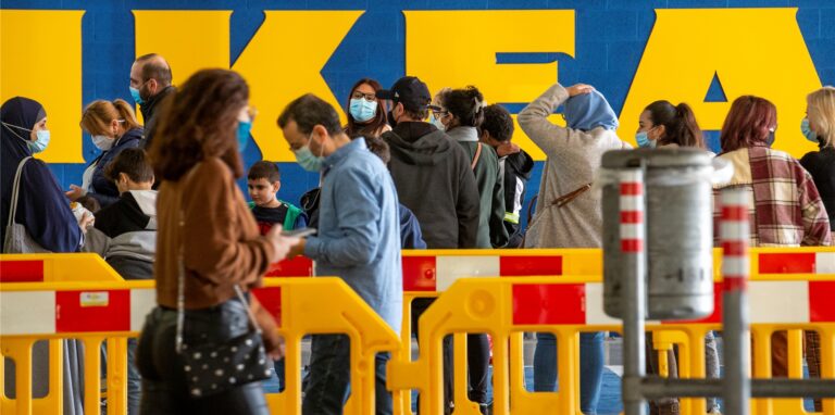Menschen stehen vor einer Filiale von IKEA in einer Schlange.