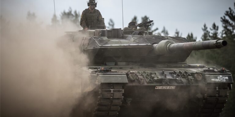 Ein Leopard-2-Panzer der Bundeswehr, der von der NATO Enhanced Forward Presence Battle Group (eFP-Bataillon) eingesetzt wird, fährt beim Besuch von Bundeskanzler Scholz durch das Camp Adrian Rohn.