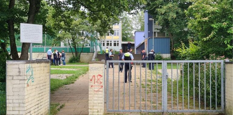 Einsatzkräfte stehen im Eingangsbereich einer Schule.