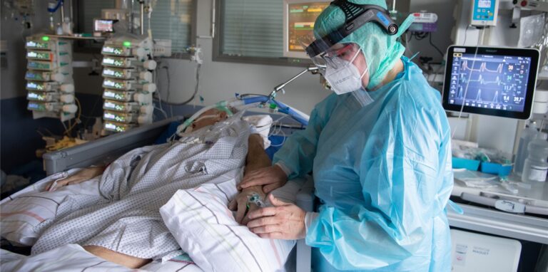 Eine Krankenschwester betreut eine Person auf der Intensivstation.
