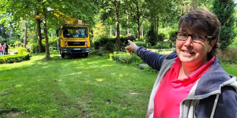 Eine Frau zeigt mit der rechten Hand auf einen Lkw