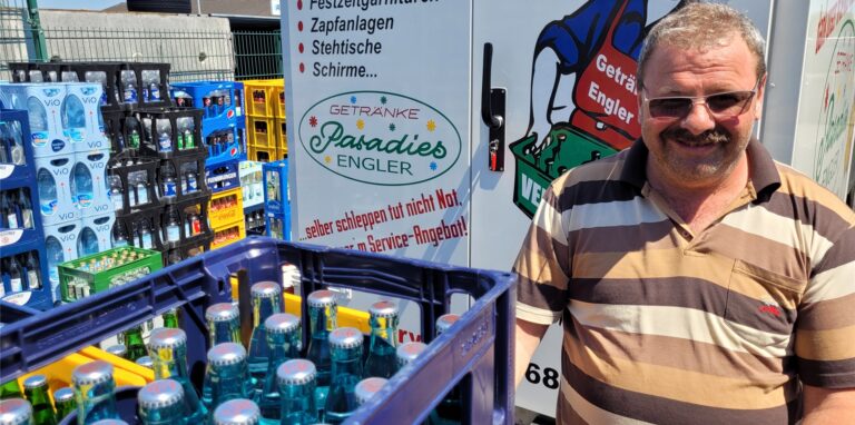 Ein Mann steht vor Mineralwasser-Leergutkisten