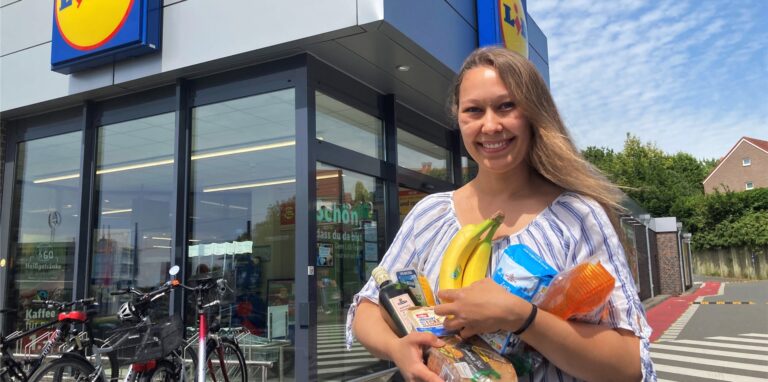 Alina Meyer steht mit sieben Artikel auf dem Arm vor Lidl.