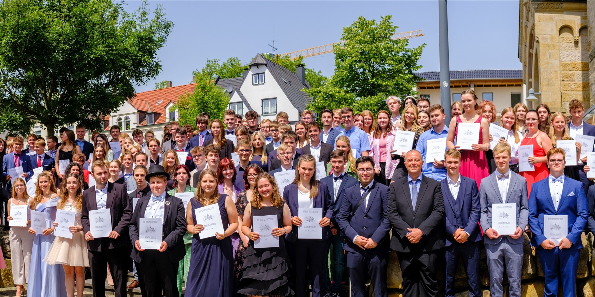 Die Schülerinnen und Schüler des Abschlussjahrgangs 2022 halten ihre Zeugnisse in den Händen.