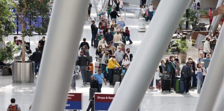 Im Düsseldorfer Flughafen stehen Menschen am Gründonnerstag, kurz vor Ostern an Schaltern zum Einchecken. 