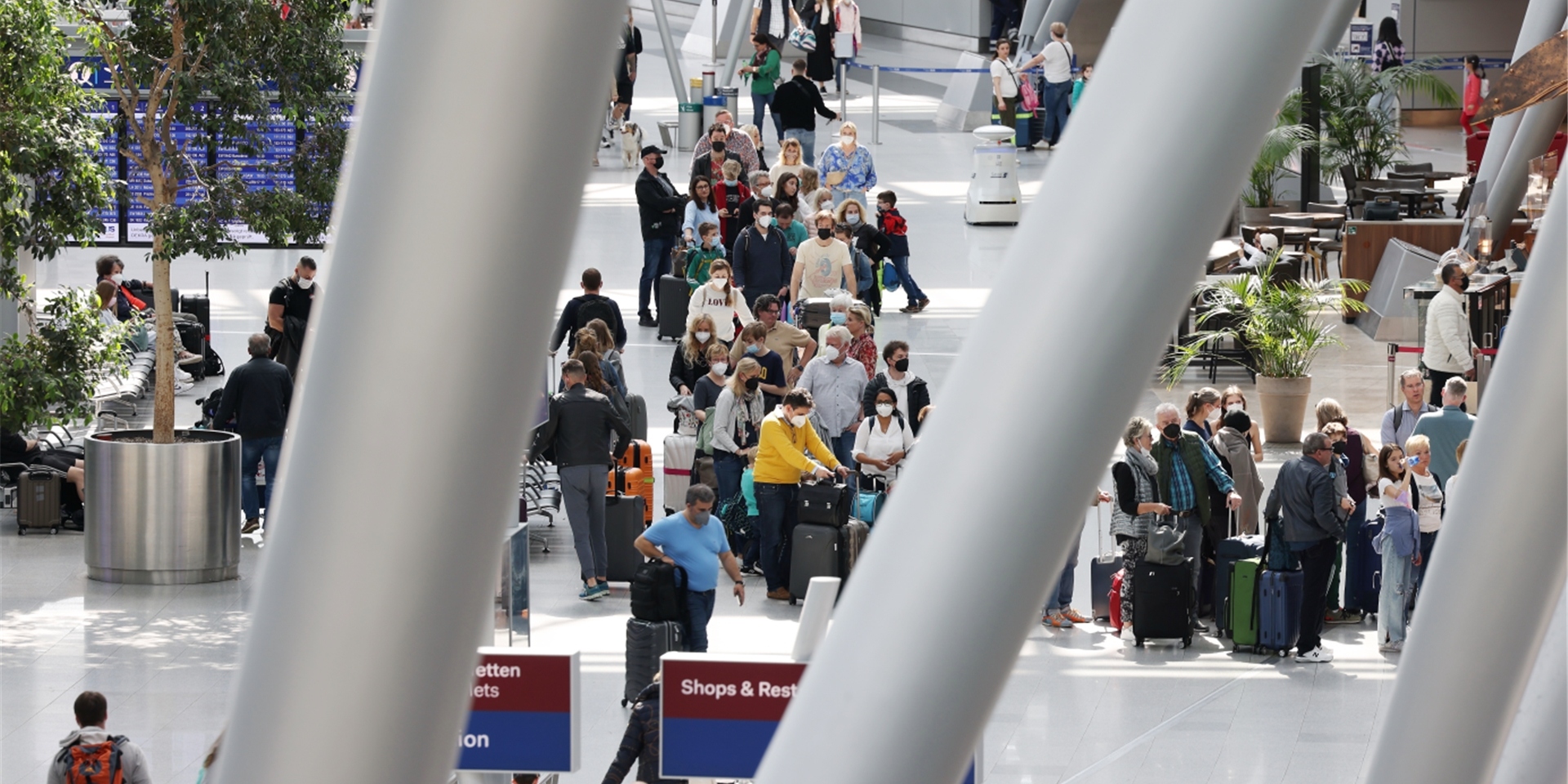 Im Düsseldorfer Flughafen stehen Menschen am Gründonnerstag, kurz vor Ostern an Schaltern zum Einchecken.