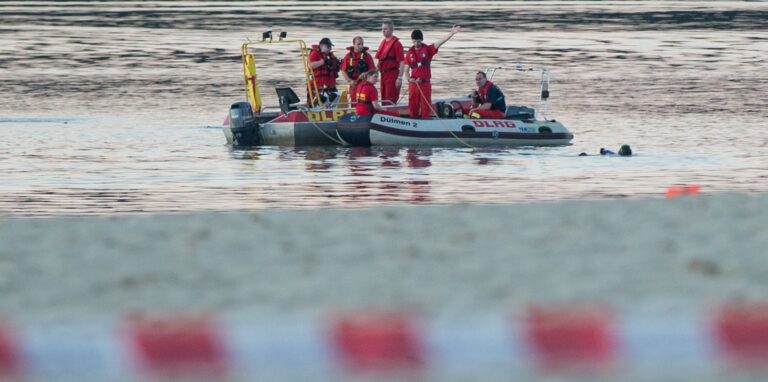 Einsatzkräfte suchen in einem Badesee nach einer vermissten Person.