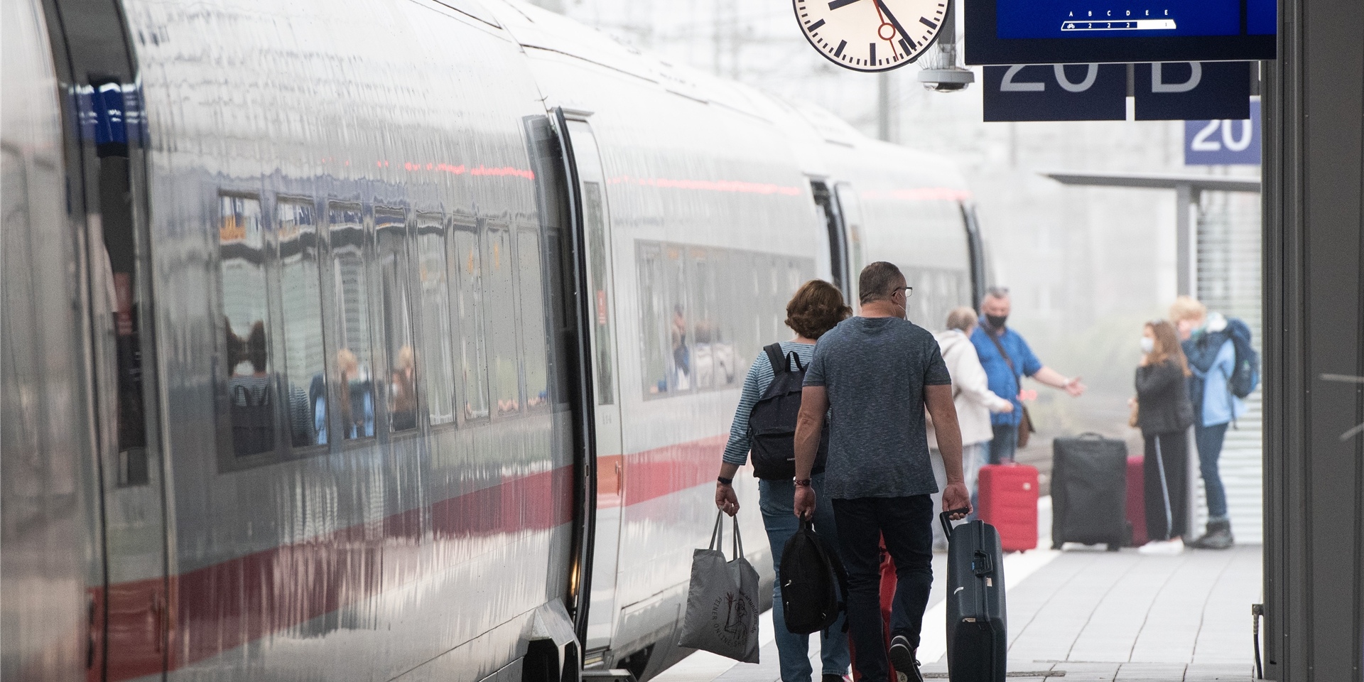 Bahnkunden gehen zu einem ICE.