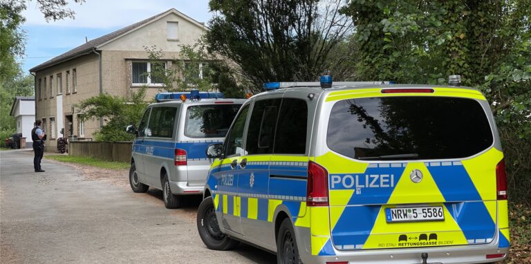 Polizeifahrzeuge stehen im Rahmen einer Grossfahndung auf einer Strasse in Kalletal.