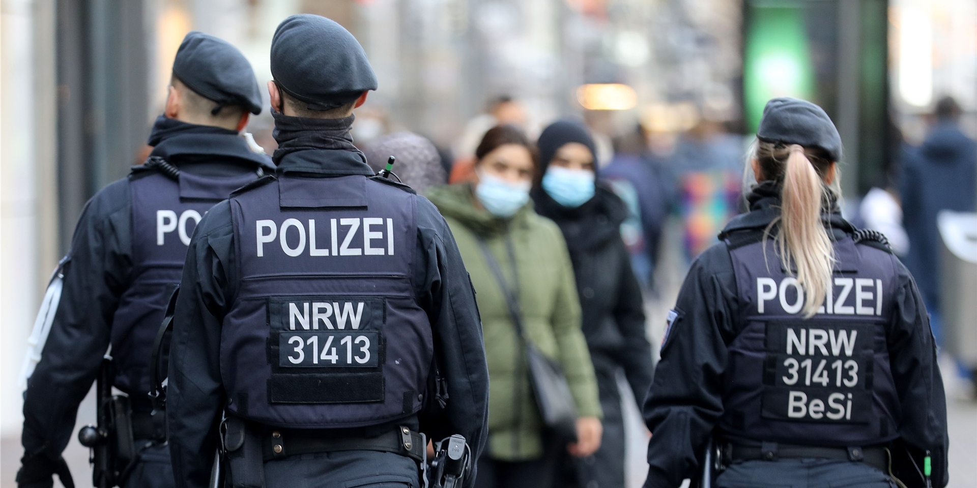 Polizisten laufen auf einer Straße.