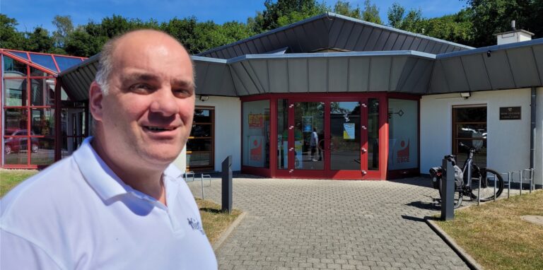 Ein Mann steht vor einem Gebäude