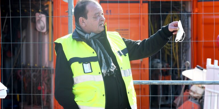 Ein Mann mit gelber Weste und Corona-Maske.