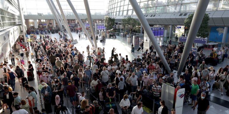 Passagiere stehen vor den Schaltern im Flughafen Düsseldorf in Schlangen und warten auf die Abfertigung.