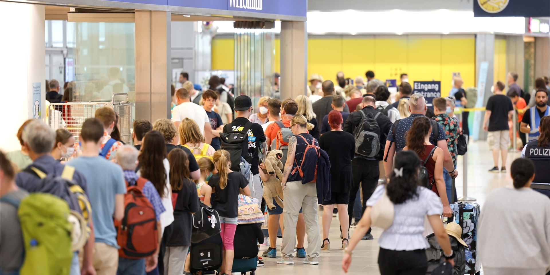 Passagiere stehen am Samstag Vormittag in einer Schlange von mehreren hundert Metern für die Sicherheitskontrolle am Flughafen Köln Bonn an.