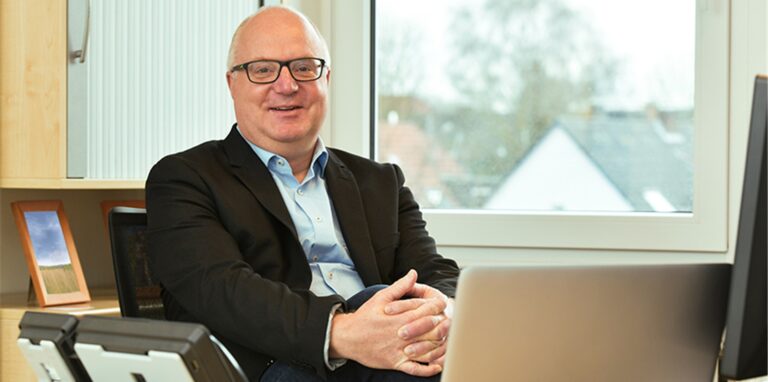 Guido Bunten sitzt in einem Büro.