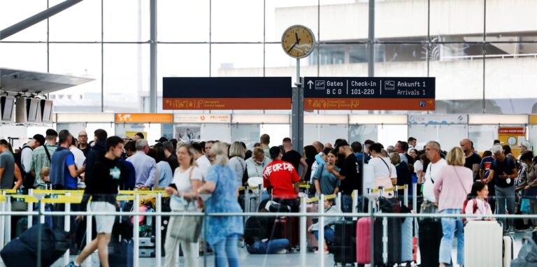 Flugreisende warten in langen Schlangen vor Check-in-Schaltern am Flughafen Köln/Bonn.