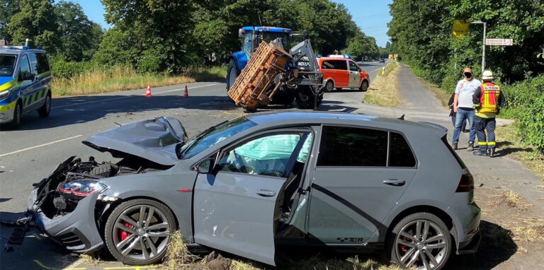 Ein demoliertes Auto steht an der Recklinghäuser Straße in Waltrop; im Hintergrund stehen Polizei- und Feuerwehrleuten und ein Traktor.