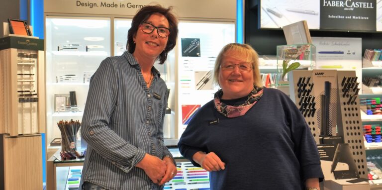 Zwei Frauen stehen vor den Lamy-Schreibgeräten im Schreibwarenladen Michelbrink.