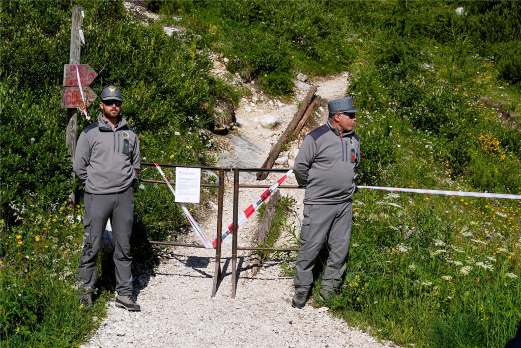 Beamte der italienischen Finanzpolizei blockieren den Zugang zum Berg Marmolata und zum Punta-Rocca-Gletscher in den italienischen Alpen. Beamte der italienischen Finanzpolizei blockieren den Zugang zum Berg Marmolata und zum Punta-Rocca-Gletscher in den italienischen Alpen.