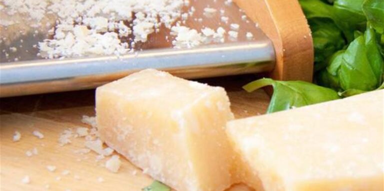 Mehrere Stücke Parmesan liegen auf einem Holzbrett.