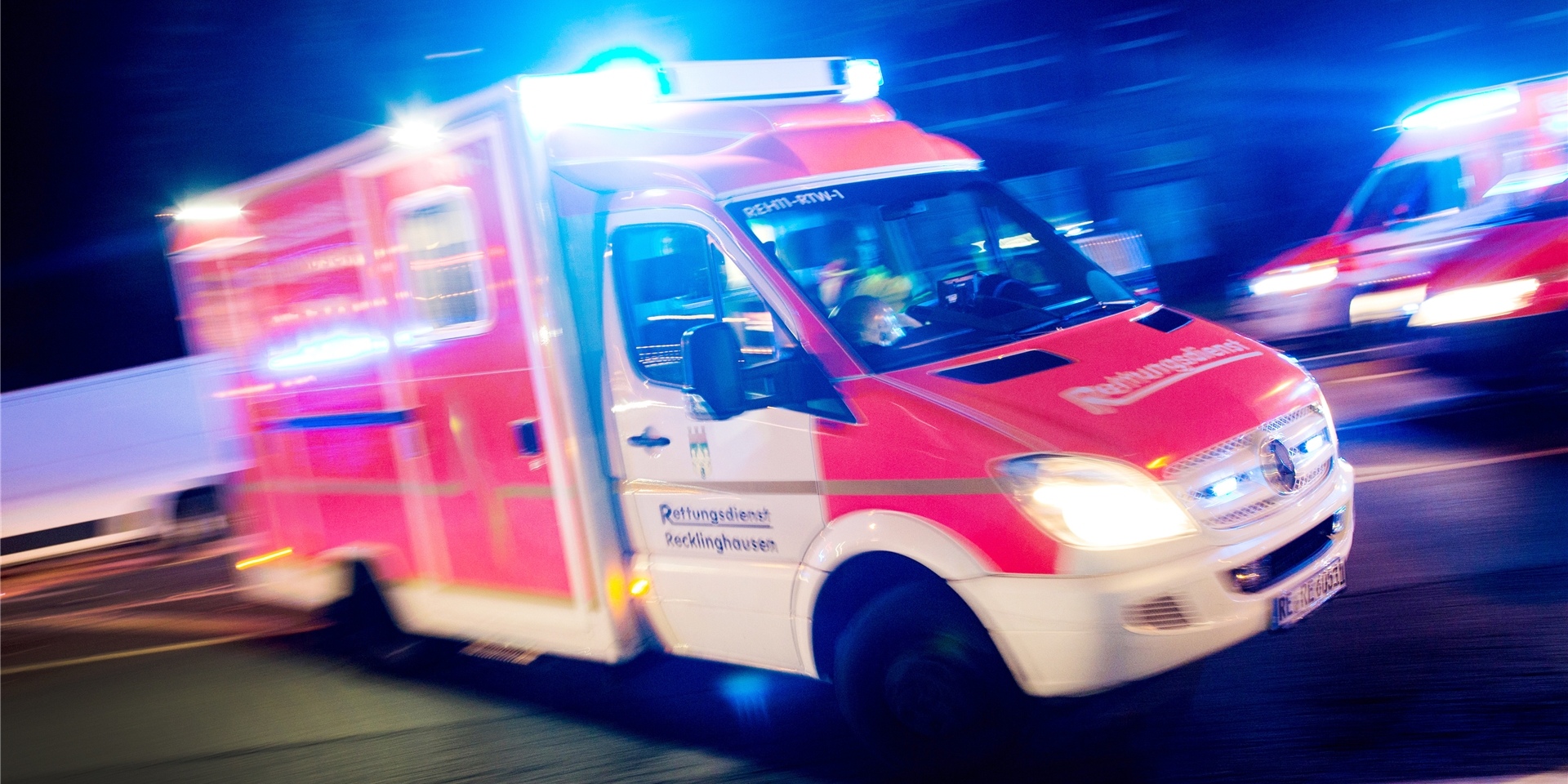 Das Symbolbild zeigt einen Krankenwagen mit Blaulicht in der Nacht.