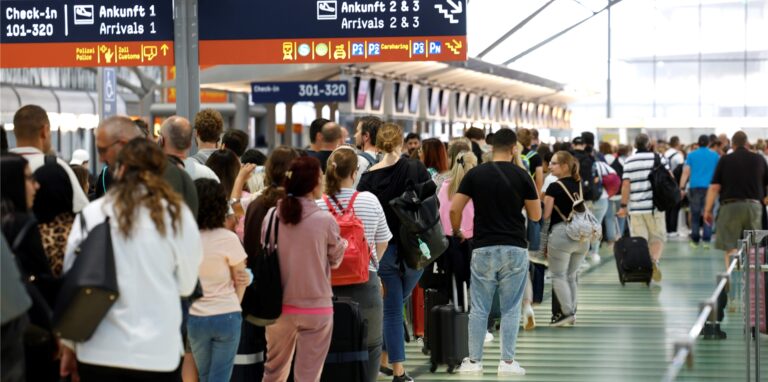 Passagiere stehen in einer Schlange von mehreren hundert Metern für die Sicherheitskontrolle am Flughafen Köln-Bonn an.