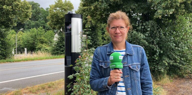 Redakteurin Tamina Forytta mit Mikro vor dem Blitzer zwischen Waltrop und  Datteln.