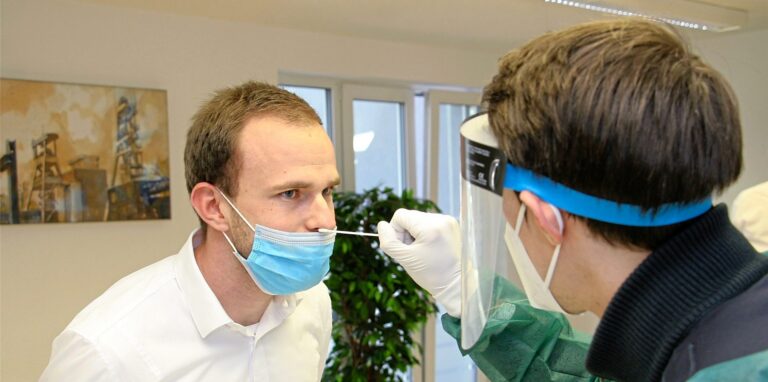 Im DRK-Testzentrum an der Gartenstraße 59 simulieren die Mitarbeiter Max-Philipp Metzemacher (r.) und René Fitze einen Corona-Test.