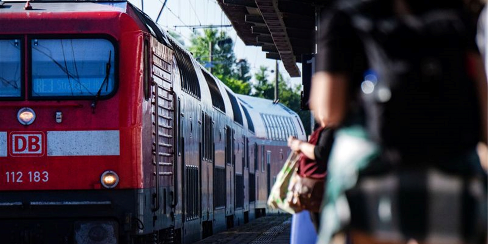 Fahrgäste warten im Bahnhof auf eine Regionalbahn.