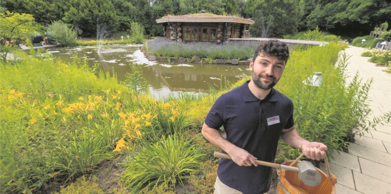 Ein Saunameister steht vor einer Sauna
