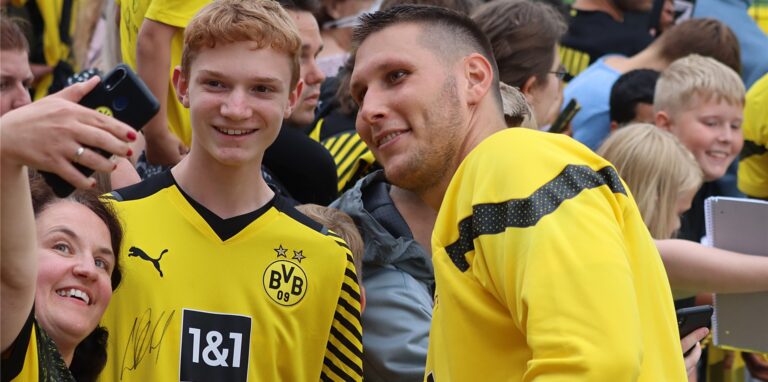 Zwei BVB-Fans machen ein Selfie mit Niklas Süle.