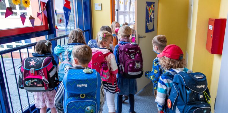 Grundschulkinder gehen in einen Klassenraum.