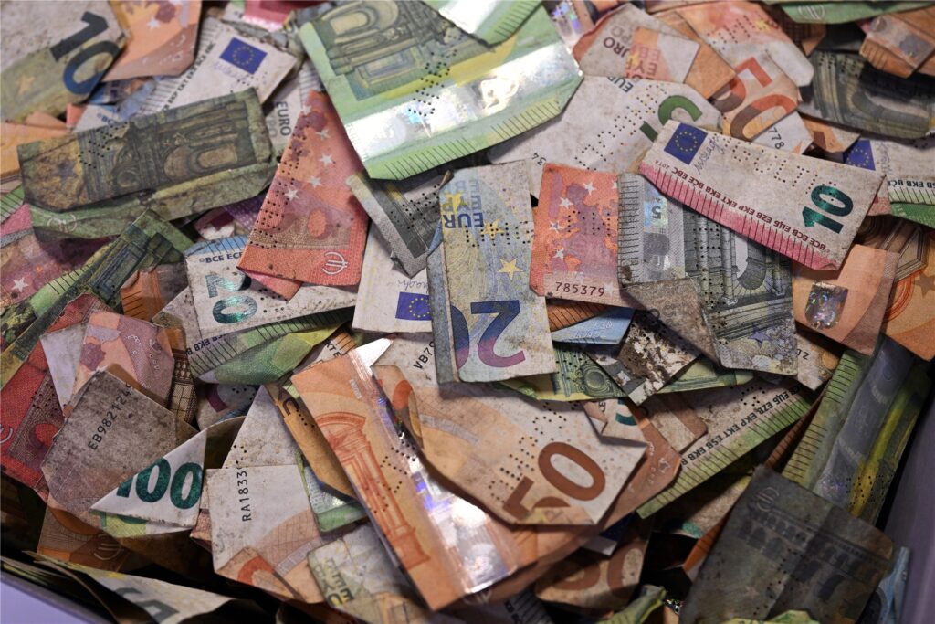 Geldscheine, die von der Bundesbank in einem Wäschetrockner getrocknet wurden, liegen in einer Kiste im Depot.