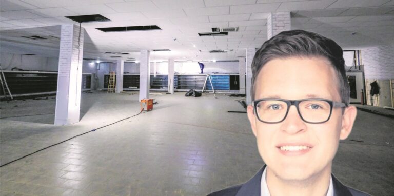 Aldi-Sprecher Dennis Boczek vor dem Innenraum des künftigen Markts im Markt-Quartier.