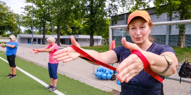 Mit Fitnessband: Übungsleiterin Karin Bertling gibt den Rhythmus beim Outdoor-Sport auf der Freizeitanlage Westerholt vor und erklärt die richtige Handhabung.