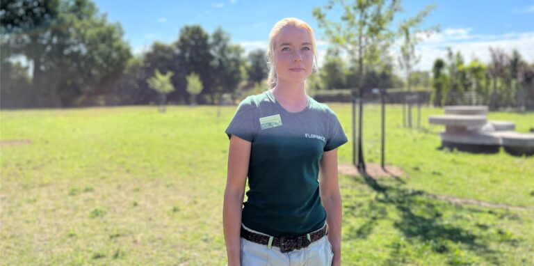 Stefanie Schüring, Mitarbeitern der Florawelt, steht auf der Wiese, auf der die Tiere grasen.