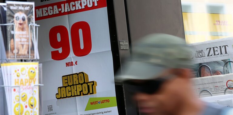 Ein Mann geht an einem Lotto-Geschäft vorbei.