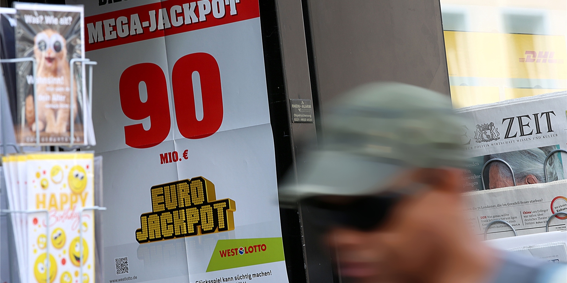 Ein Mann geht an einem Lotto-Geschäft vorbei.