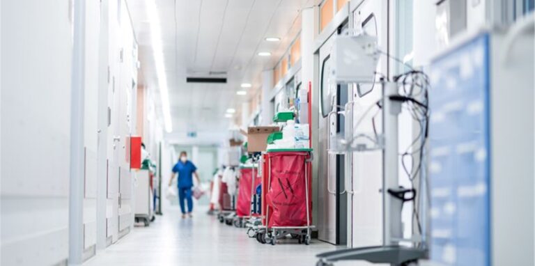 Eine Pflegekraft geht auf einer Intensivstation über den Flur.