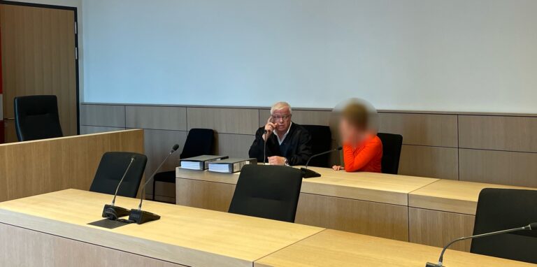 Ein Mann und eine Frau sitzen in einem Gerichtssaal