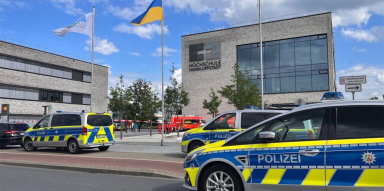 An der Hochschule Hamm-Lippstadt hat ein 34-jähriger Mann mit einem Messer mehrere Menschen angegriffen und vier Personen verletzt, einige von ihnen schwer. Polizeiwagen stehen auf dem Campus.