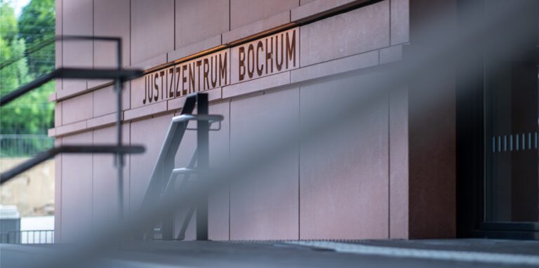 An der Treppe stehen beim Landgericht die Wörter: «Justizzentrum Bochum» in Stein gemeißelt.
