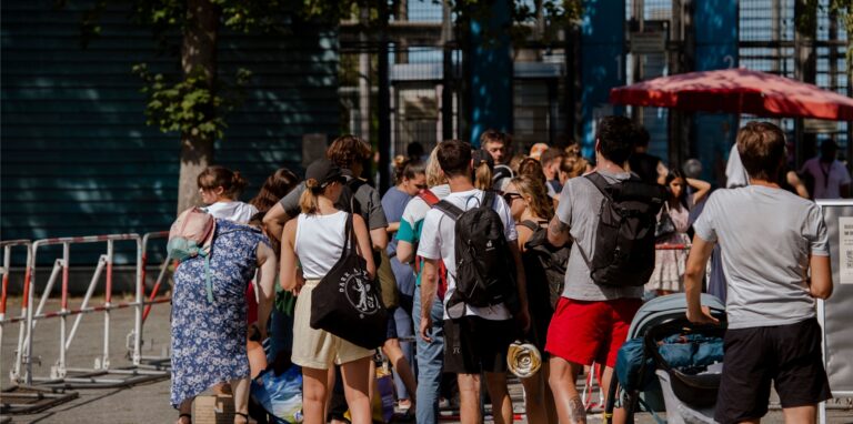 Zahlreiche Menschen stehen an den Kassen des Sommerbades Neukölln am Columbiadamm.