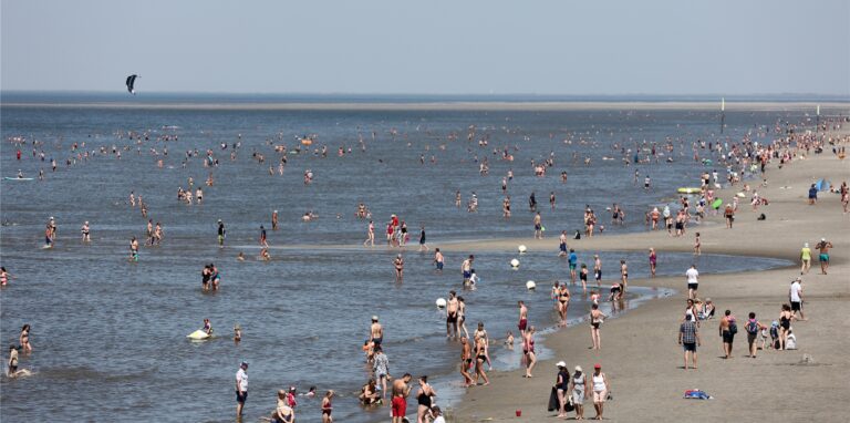 Zahlreiche Urlauber genießen die Sonne am Strand.