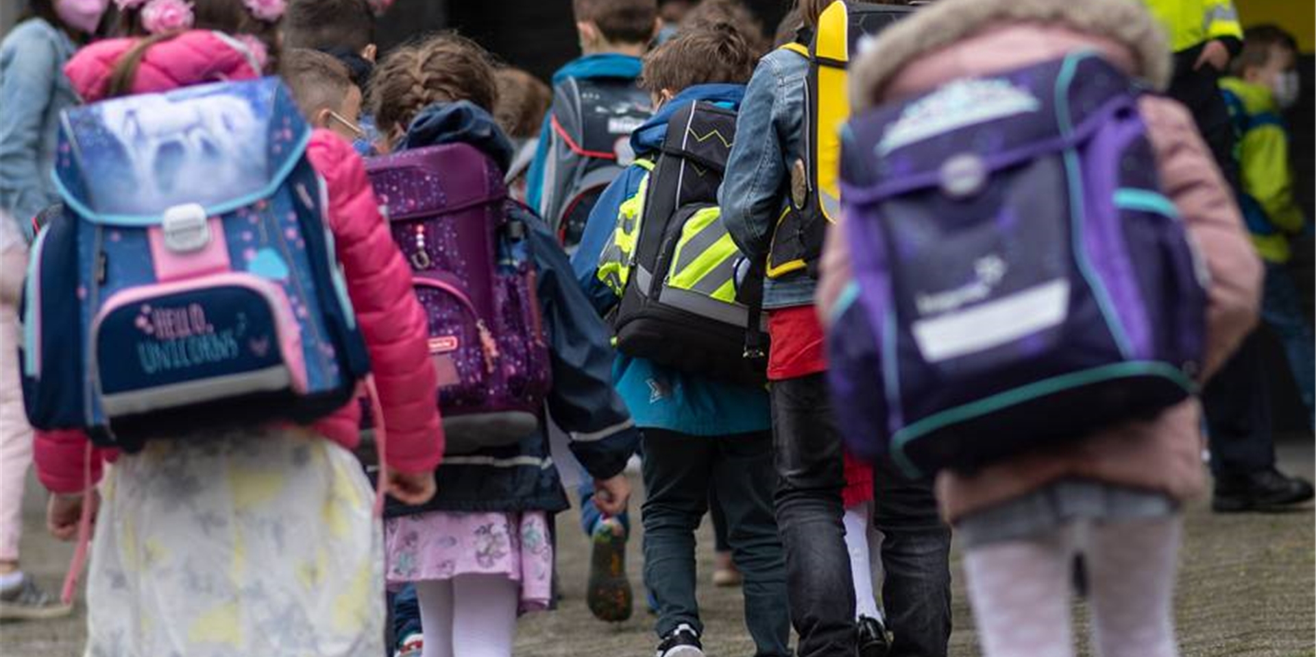 Kinder mit Schulranzen gehen in einer Gruppe.